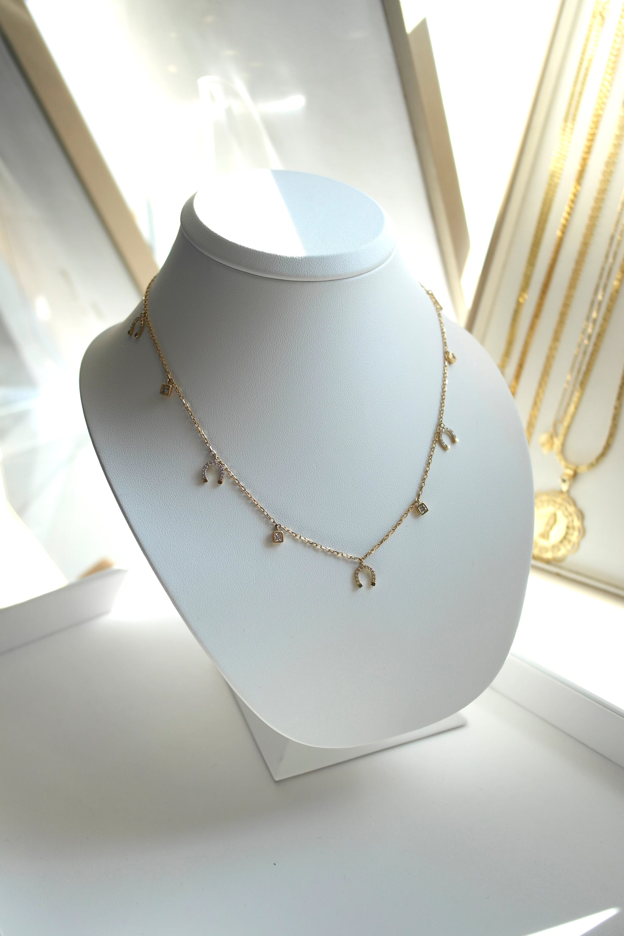 Naszyjnik z zawieszkami w kształcie podków i kryształków