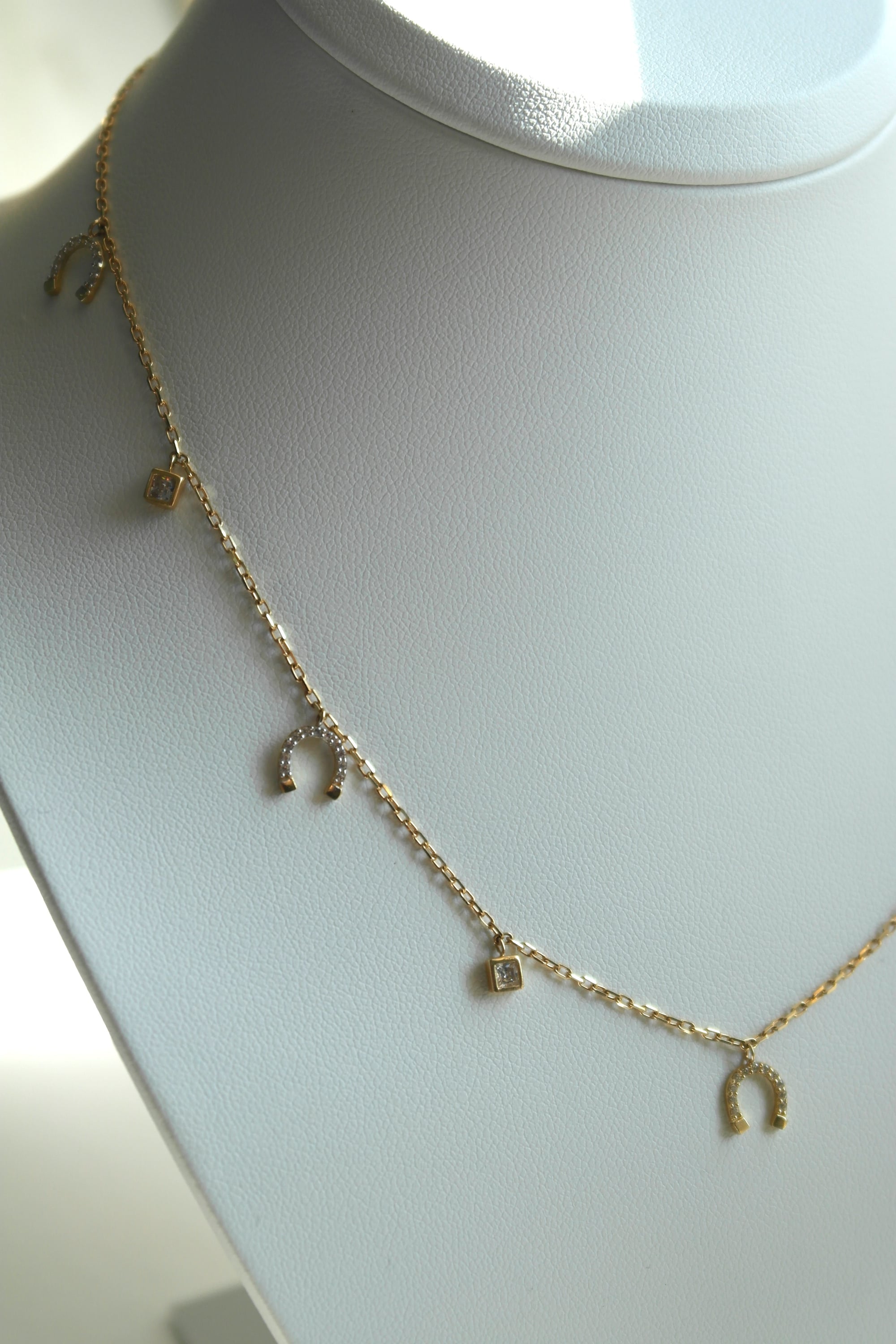 Naszyjnik z zawieszkami w kształcie podków i kryształków